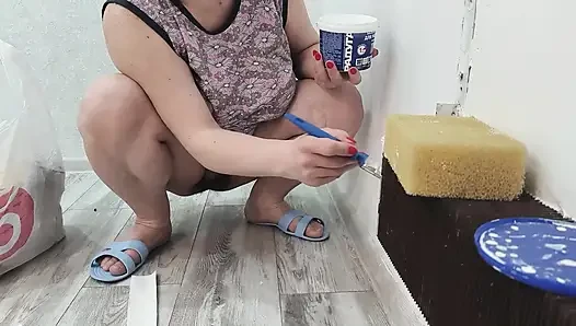 A milf paints a radiator without panties.