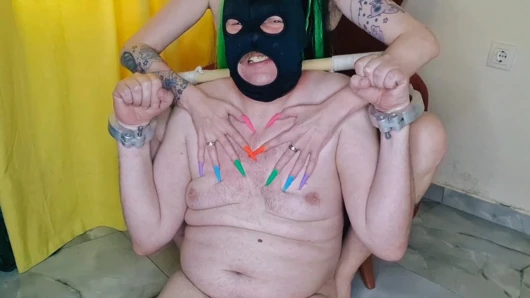 Long nail fetish. Dominatrix Nika has a new multi-colored manicure. She digs her nails painfully into her slave's flesh.