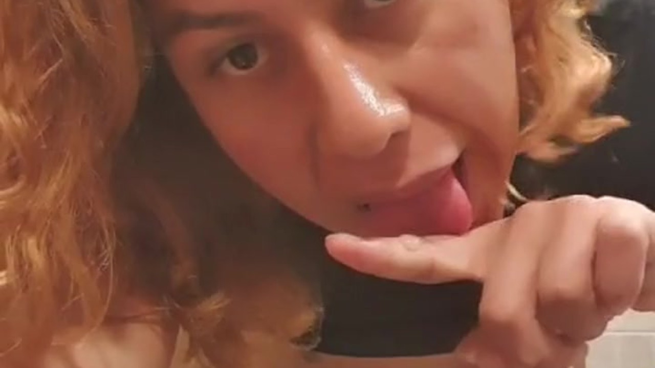Jovencita trans jugando en el espejo del baño