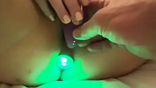 Vibrating dildo is in her pussy while lightshow butt plug is in her rectum